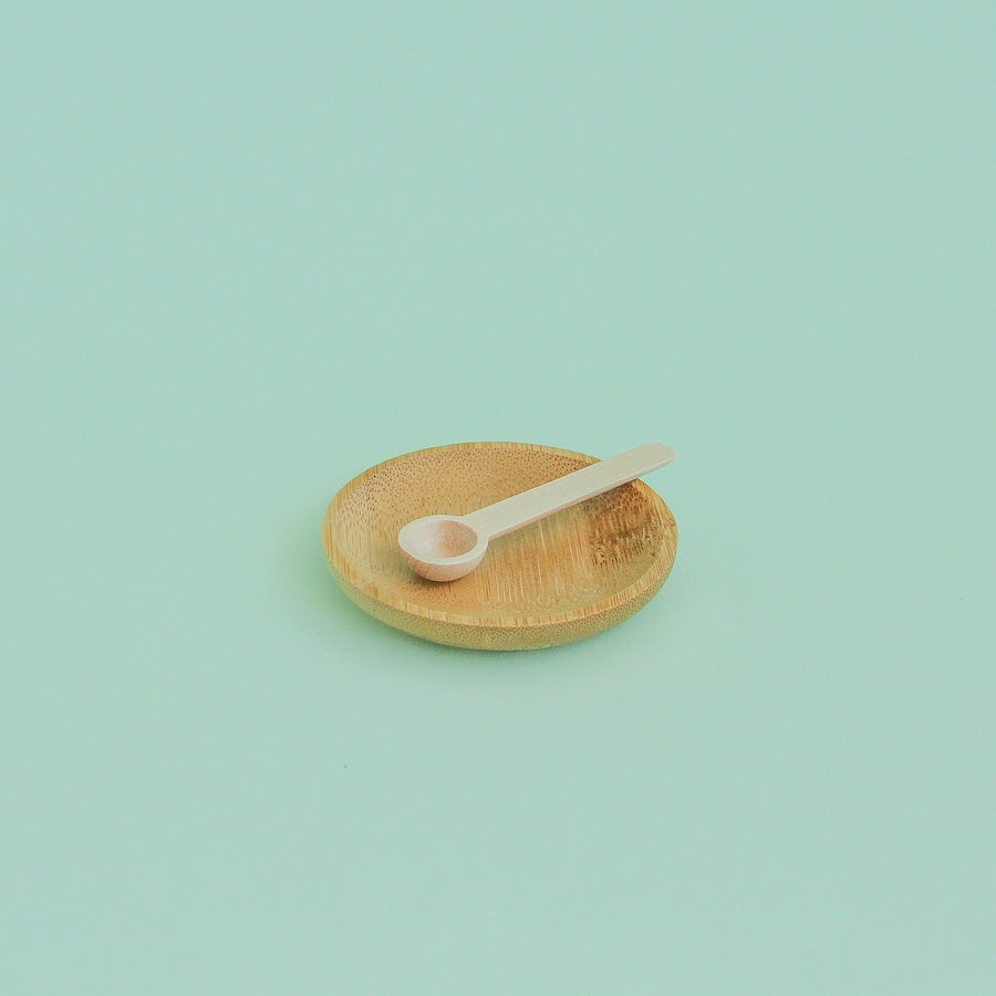 Platito de madera redondo sobre fondo verde menta