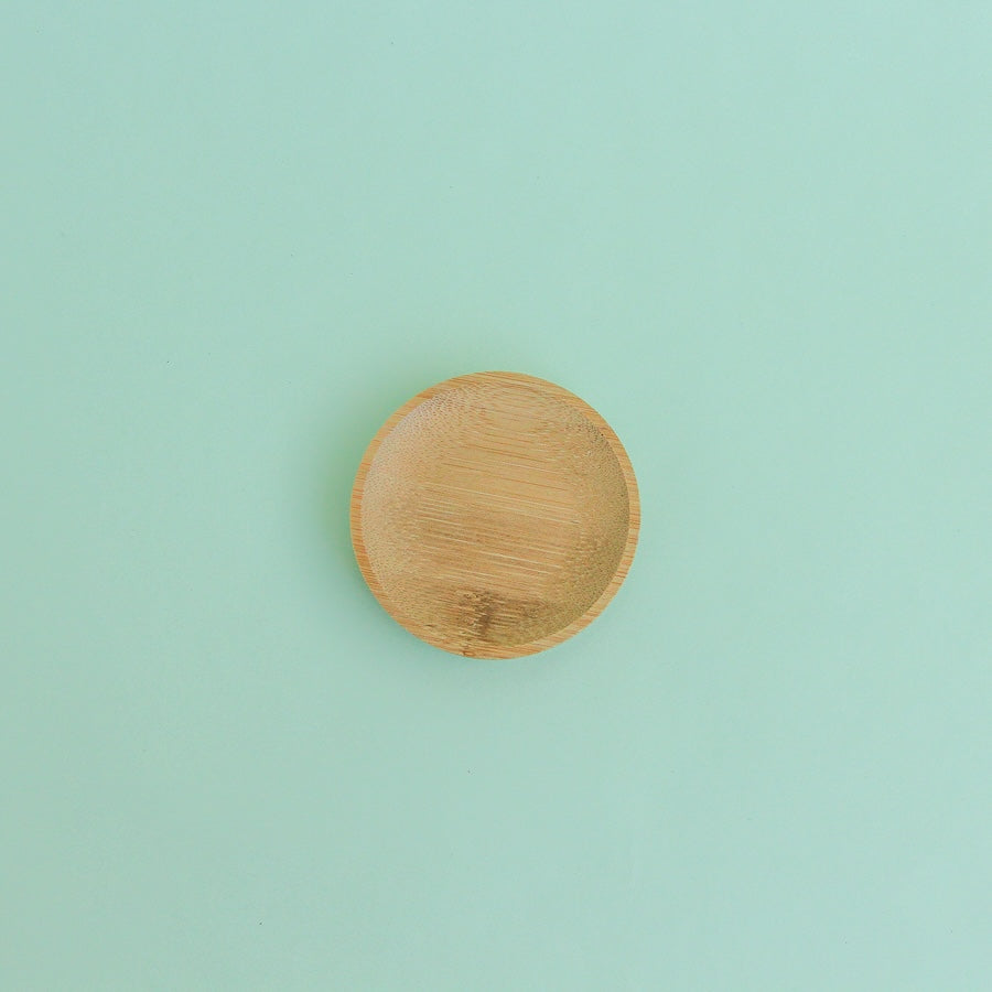 Platito de madera redondo sobre fondo verde menta