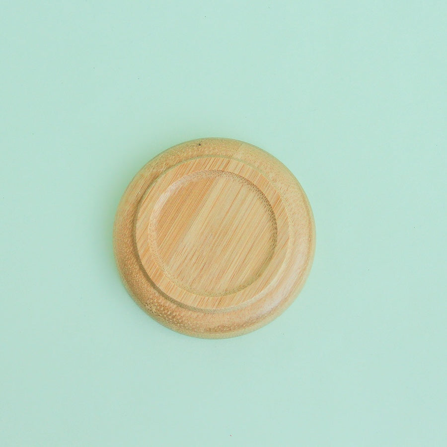 Platito de madera redondo sobre fondo verde menta