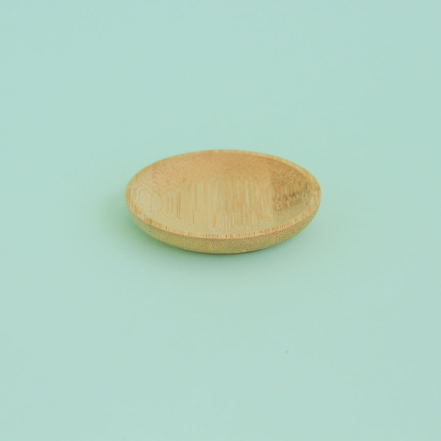 Platito de madera redondo sobre fondo verde menta
