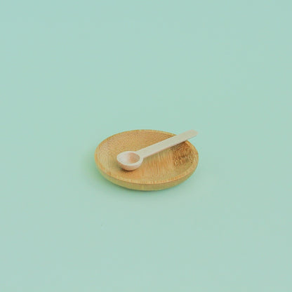 Platito de madera redondo sobre fondo verde menta