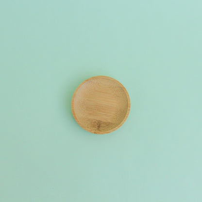 Platito de madera redondo sobre fondo verde menta