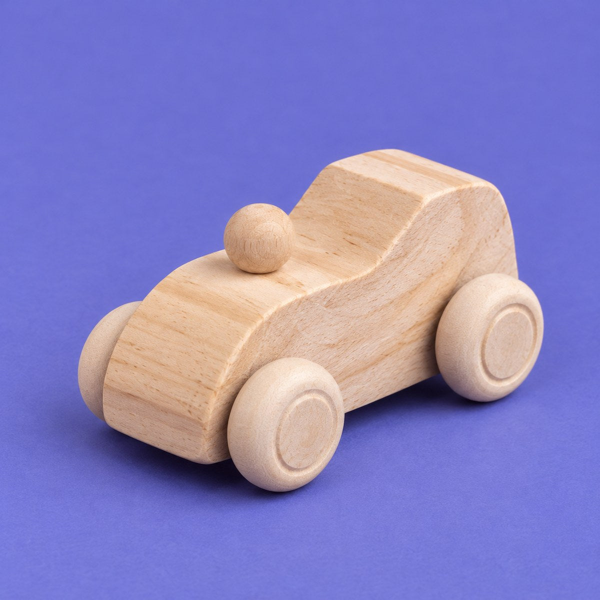 Un coche de madera natural sin pintar con sus 4 ruedas